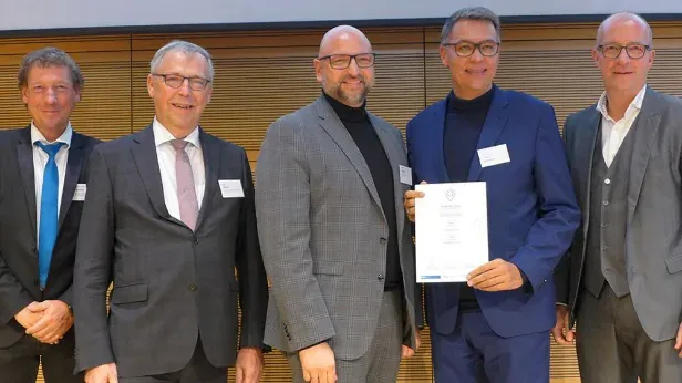Fünf Personen stehen nebeneinander auf der Bühne, eine von ihnen hält die Urkunde des Wifö-Awards 2019 in den Händen.